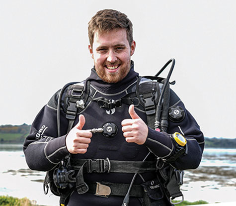 Smiling James McKenna in full kit, sending a double thumbs up at the viewer